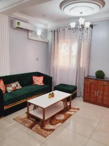 een woonkamer met een groene bank en een salontafel bij OLD Bonapriso Paisible Appart meublé 2 Chambres in Douala