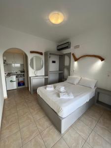 a bedroom with a large white bed in a room at Alexandra’s studios in Irakleia
