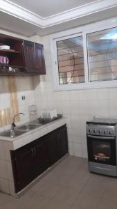 cocina con fregadero y fogones en OLD Bonapriso Paisible Appart meublé 2 Chambres, en Douala
