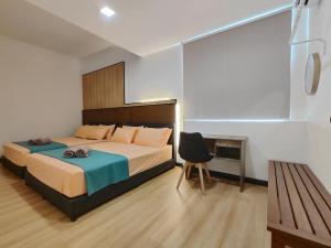 a bedroom with a bed and a chair in it at Queensway2 Homestay, 4 Rooms 10pax in Sibu