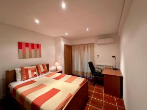 Schlafzimmer mit einem Bett, einem Schreibtisch und einem Stuhl in der Unterkunft Casa da Clarinha in Penalva do Castelo
