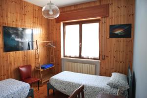 1 dormitorio con 2 camas y ventana en B&B All'Antica Fonte en Forgaria nel Friuli