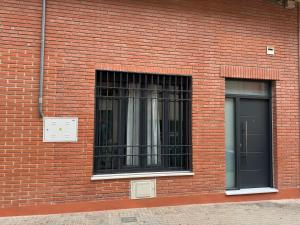 a brick building with two windows and a door at La Estrella del Marrubial in Córdoba