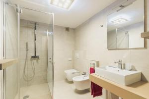 a bathroom with a sink and a shower and a toilet at Hotel Garni Ischia in Malcesine