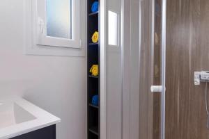 a bathroom with a shower and a glass door with a wine rack at Résidence Les Trois Mâts à Trestel, en bord de mer, sur la Côte de Granit Rose in Trévou-Tréguignec