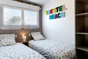 a bedroom with a bed and a sign on the wall at Résidence Les Trois Mâts à Trestel, en bord de mer, sur la Côte de Granit Rose in Trévou-Tréguignec +5 photos