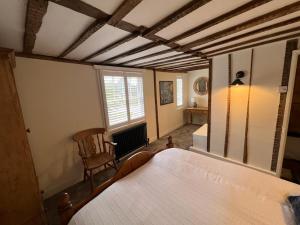 a bedroom with a large bed and a chair at The Cottage, 13 Golden Sq. in Kent