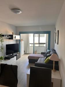 ein Wohnzimmer mit einem Sofa und einem Flachbild-TV in der Unterkunft Casa Matilde in Corralejo