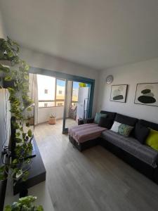ein Wohnzimmer mit einem Sofa und einem großen Fenster in der Unterkunft Casa Matilde in Corralejo