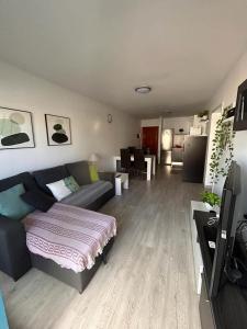 ein Wohnzimmer mit einem Sofa und einem Tisch sowie eine Küche in der Unterkunft Casa Matilde in Corralejo