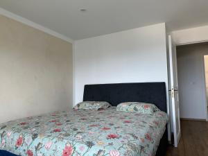 um quarto com uma cama com um edredão floral em Appartement vue mer , plage à 50m em Six-Fours-les-Plages