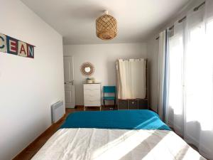 um quarto com uma cama com um cobertor azul em Maison Familiale Proche Plage, Marché & Commerces - 6 pers. Classée 3 étoiles em La Brée-les-Bains