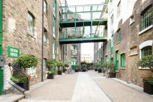 un callejón con una pasarela entre dos edificios en Designer Warehouse Two Bedrooms Converted, London Bridge, en Londres