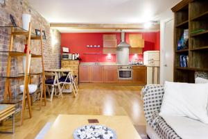 a kitchen with red walls and a living room at Designer Warehouse Two Bedrooms Converted, London Bridge in London