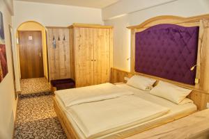 a bedroom with a large bed with a purple headboard at Hotel Gondel in Altenkunstadt