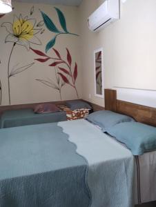 a bedroom with two beds and a painting on the wall at Nascer do Sol Kitesurf House in Fortim