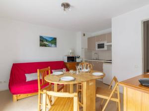 - une cuisine et une salle à manger avec une table et un canapé rouge dans l'établissement Appartement Cauterets, 2 pièces, 6 personnes - FR-1-401-91, à Cauterets