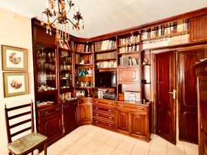 a library with wooden cabinets and a chandelier at Vivienda La Puerta del Perdon in Constantina +24 photos