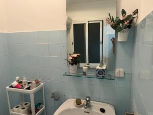 a blue tiled bathroom with a sink and a mirror at Vivienda La Puerta del Perdon in Constantina
