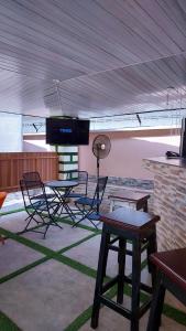 Habitación con sillas, mesa y TV. en Cogent Apartments en Uyo