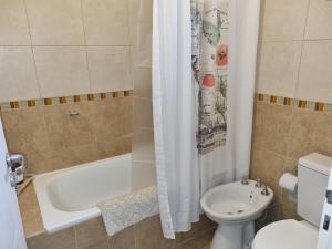 een badkamer met een bad, een toilet en een wastafel bij Departamento Las Calandrias in Cipolletti