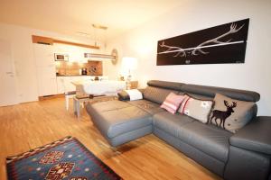 salon ze skórzaną kanapą i kuchnią w obiekcie Apartment mit Garten Alpinum Residence Lungau TOP 08 w mieście Tamsweg