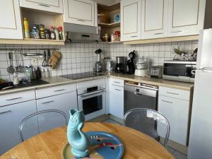 a kitchen with a table with a toy lizard on it at Maison entre marché et plages de Royan in Royan