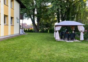 een tuinhuisje met tafels en stoelen in een tuin bij Jaukus butas gražiame name su sodu in Druskininkai