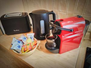 a counter with a coffee maker and a toaster at MRODBNB - Appart Neuf - Aperçu Mer - 25m Plage & Resto - Ciné - cheminée - Popcorn in Cancale +11 photos
