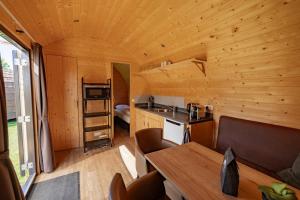 a kitchen and dining room of a log cabin at Family Woodlodge High Chaparral in Oorsbeek