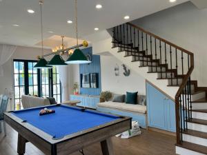 a living room with a pool table and stairs at KB Villas in Bình Sum