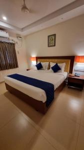 a bedroom with a large bed with blue pillows at A K Residency in Kālapettai