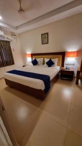 a bedroom with a large bed with blue pillows at A K Residency in Kālapettai