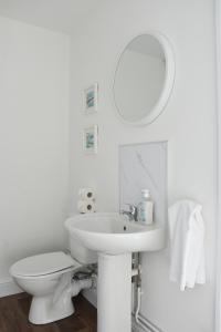 a white bathroom with a sink and a toilet at The Whitehouse in Norwich