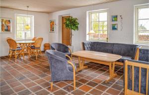 Beautiful Home In Ansager With Wifi في Ansager: غرفة معيشة مع أريكة وطاولة وكراسي