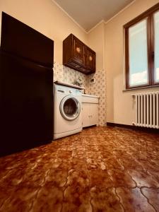 a laundry room with a refrigerator and a washer at Il vecchio granaio in Ruino
