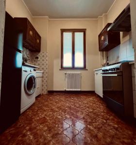 a kitchen with a washing machine and a window at Il vecchio granaio in Ruino
