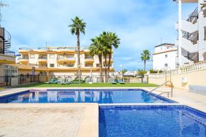 a swimming pool in front of a building at Villamartin apartment. Excellent location for Golfers, Cyclists and Hikers in Villamartin