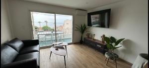 ein Wohnzimmer mit einem Sofa und einem großen Fenster in der Unterkunft Appartement vue mer , plage à 50m in Six-Fours-les-Plages