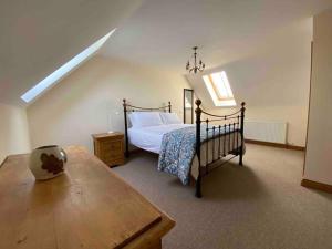 a bedroom with a bed and a wooden table at Mallards Barn on a rural farm in Dingestow