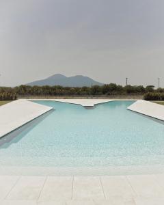 a swimming pool with blue water and mountains in the background at Secret Garden Resort & Spa in Palma Campania