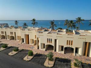 a large building with the ocean in the background at Radwa Ramada Resort in Yanbu