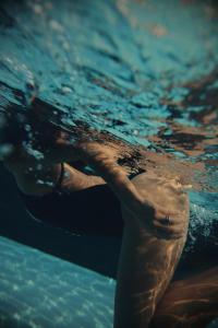 osoba pływa w wodzie w obiekcie Secret Garden Resort & Spa w mieście Palma Campania