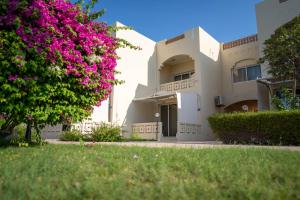 a building with pink flowers in front of it at Radwa Ramada Resort in Yanbu