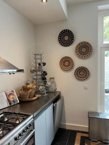 a kitchen with a stove and plates on the wall at Monumentale stadswoning in hartje binnenstad in Maastricht