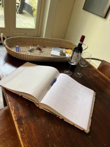 un libro abierto sobre una mesa con una botella de vino en Monumentale stadswoning in hartje binnenstad, en Maastricht