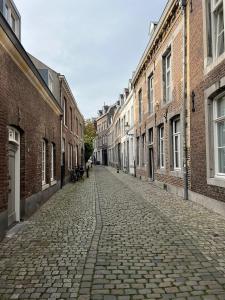 una strada ciottolata vuota in una città con edifici di Monumentale stadswoning in hartje binnenstad a Maastricht