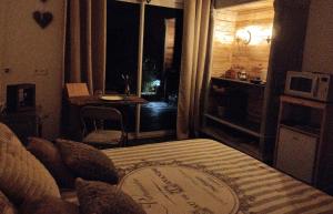 um quarto com uma cama e uma mesa num quarto em La guitoune em Laroque