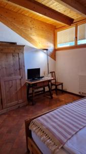 um quarto com uma secretária e uma cama num quarto em Weisses Kreuz - Crusch Alva em Samedan