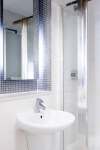 a white bathroom with a sink and a shower at Designer Warehouse Two Bedrooms Converted, London Bridge in London